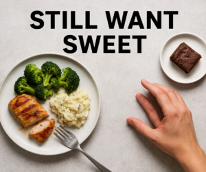 Overhead dinner plate with keto food partly eaten while a hand reaches toward a small dessert, with bold text STILL WANT SWEET